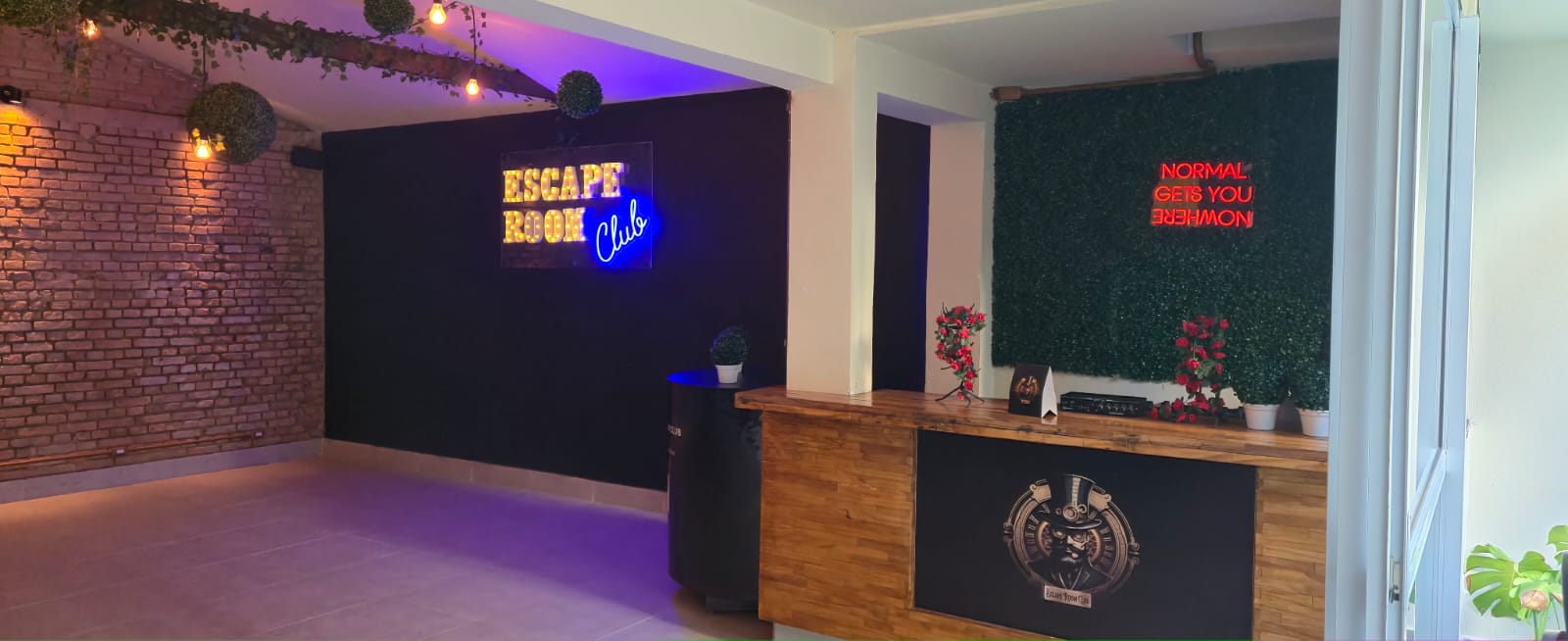 Salão do Escape Club com letreiro luminoso, parede de tijolos e recepção em madeira